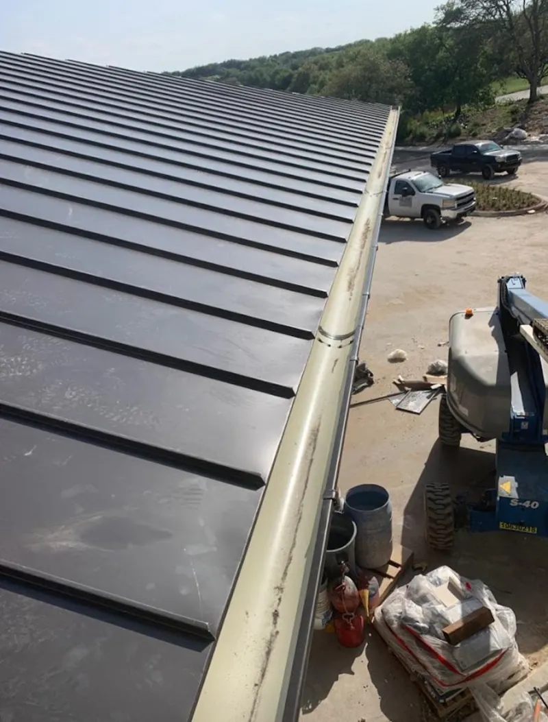 Standing seam panel and gutter detail on a metal roofing jobsite in Ulysses